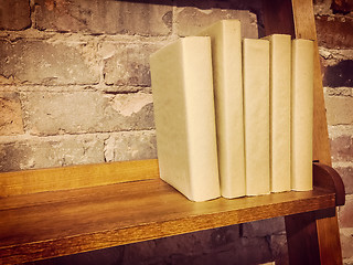 Image showing Books in paper covers on a wooden shelf