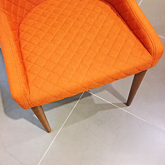 Image showing Bright orange armchair on tile floor