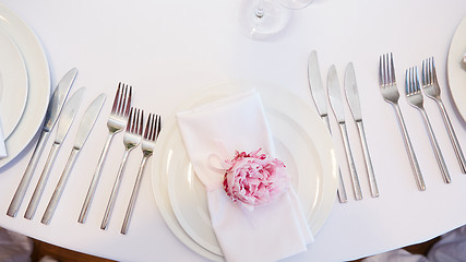 Image showing Spring table settings with fresh flower, napkin and silverware. Holidays background. Selective Focus.