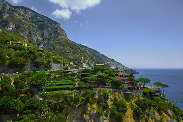 Image showing One of the best resorts of Italy with old colorful villas on the steep slope, nice beach, numerous yachts and boats in harbor and medieval towers along the coast, Positano.