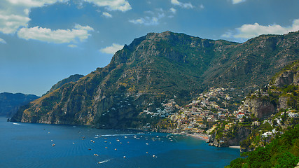 Image showing One of the best resorts of Italy with old colorful villas on the steep slope, nice beach, numerous yachts and boats in harbor and medieval towers along the coast, Positano.