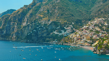 Image showing One of the best resorts of Italy with old colorful villas on the steep slope, nice beach, numerous yachts and boats in harbor and medieval towers along the coast, Positano.