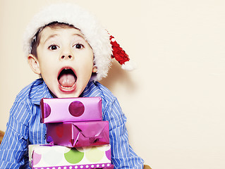 Image showing little cute boy with Christmas gifts at home. close up emotional