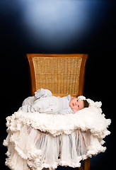 Image showing Newborn baby girl with sleeping on a wooden chair