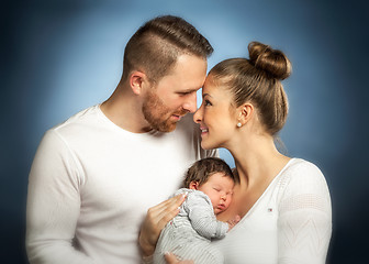 Image showing Portrait of young happy couple embracing to their newborn.
