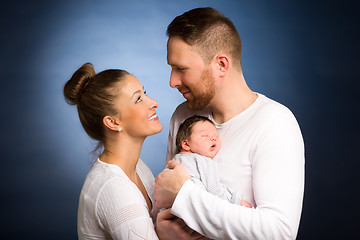 Image showing Portrait of young happy couple embracing to their newborn.