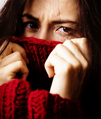 Image showing young brunette gloomy woman in sweater all over her face, messed hair