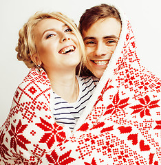 Image showing young pretty teenage couple at Christmas time warming in red decorated blanket, hipster guy with his girlfriend happy smiling and hugging isolated on white background, lifestyle people concept 