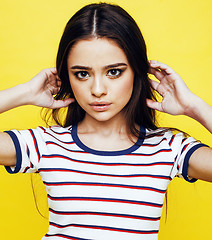 Image showing lifestyle people concept: pretty young school teenage girl having fun happy smiling on yellow background 