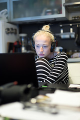 Image showing Adult woman in her casual home clothing working and studying remotely from her small flat late at night.