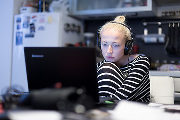 Image showing Adult woman in her casual home clothing working and studying remotely from her small flat late at night.