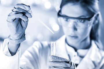 Image showing Young scientist pipetting in life science laboratory.