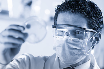 Image showing Life science researcher observing cells in petri dish.