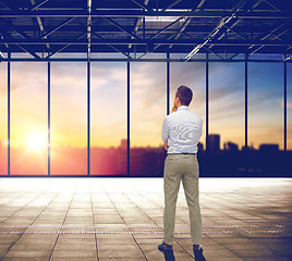 Image showing businessman thinking over office and city view