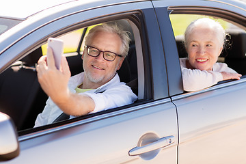 Image showing senior couple in car taking smartphone selfie