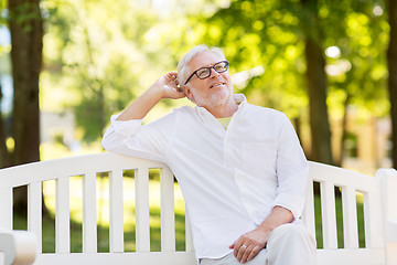 Image showing happy senior man in glasses sitting at summer park