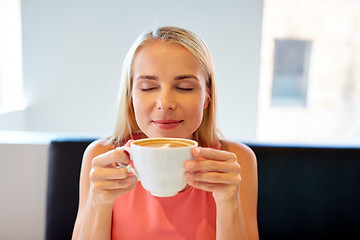 Image showing close up of woman drinking coffee at restaurant