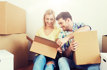 Image showing smiling couple with many boxes moving to new home