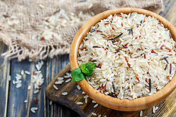 Image showing Red, white, brown and wild rice in a wooden bowl closeup.