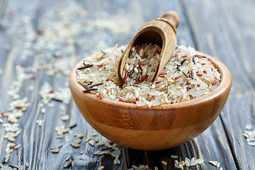 Image showing Wooden scoop in a bowl with a mixture of four types of rice.