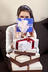 Image showing girl holds one of the many gift boxes