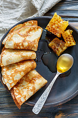 Image showing Crepes and honey for a delicious breakfast.