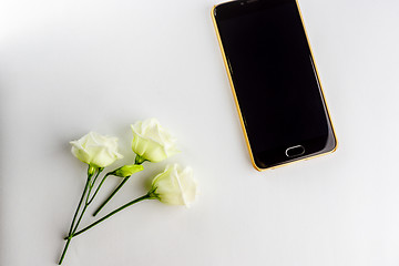 Image showing Small flowers and modern stylish smartphone