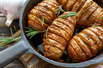 Image showing Potatoes in their skins baked with rosemary.