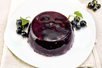 Image showing Jelly from black currant with berries in plate on stone table