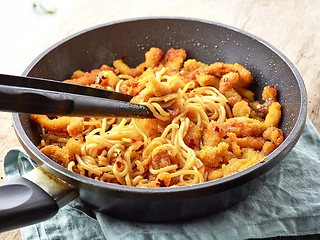 Image showing Asian noodles with fried meat on cooking pan