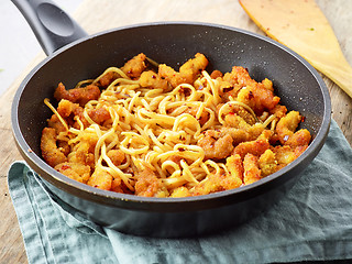 Image showing Asian noodles with fried meat on cooking pan