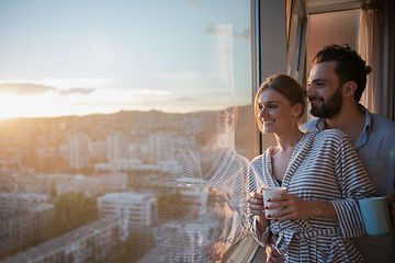 Image showing young couple enjoying evening coffee by the window