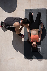 Image showing woman with personal trainer doing morning yoga exercises top vie