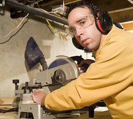 Image showing Young Man Sawing Some Wood