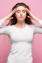Image showing Portrait of beautiful young brunette with bare shoulders touching her temples feeling stress