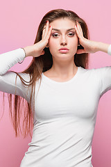 Image showing Portrait of beautiful young brunette with bare shoulders touching her temples feeling stress