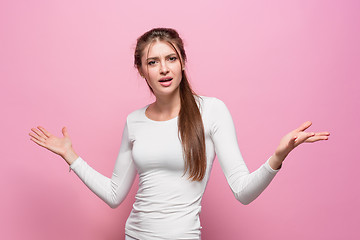 Image showing The serious frustrated young beautiful business woman on pink background