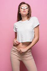 Image showing Pretty young sexy fashion sensual woman posing on pink background dressed in hipster style jeans