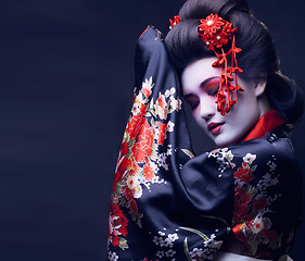 Image showing young pretty geisha in kimono with sakura and decoration