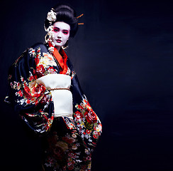 Image showing young pretty geisha in kimono with sakura and decoration