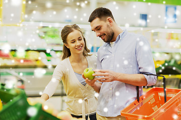 Image showing happy couple buying apples at grocery store