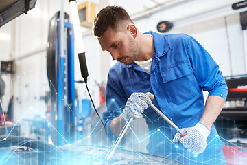 Image showing mechanic man with wrench repairing car at workshop