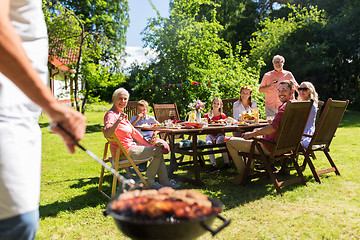 Image showing man cooking meat on barbecue grill at summer party