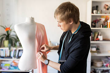 Image showing fashion designer with dummy making dress at studio