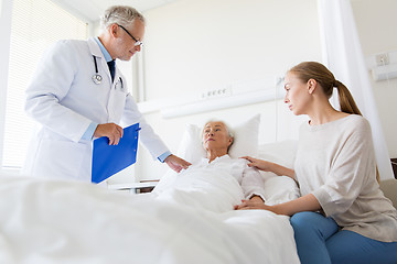 Image showing senior woman and doctor with clipboard at hospital