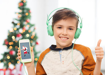 Image showing boy with smartphone and headphones at christmas