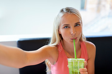 Image showing woman with smoothie taking selfie at restaurant