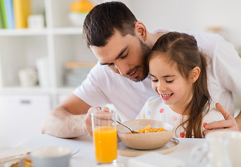 Image showing happy family eating flakes for breakfast at home