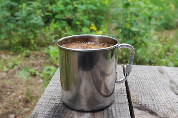 Image showing Metal mug of coffee on wooden table