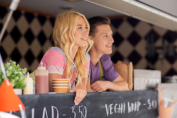 Image showing happy young sellers at food truck